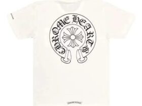 Chrome Hearts silver cross pendant resting on a heavyweight black streetwear hoodie with denim jeans in the background